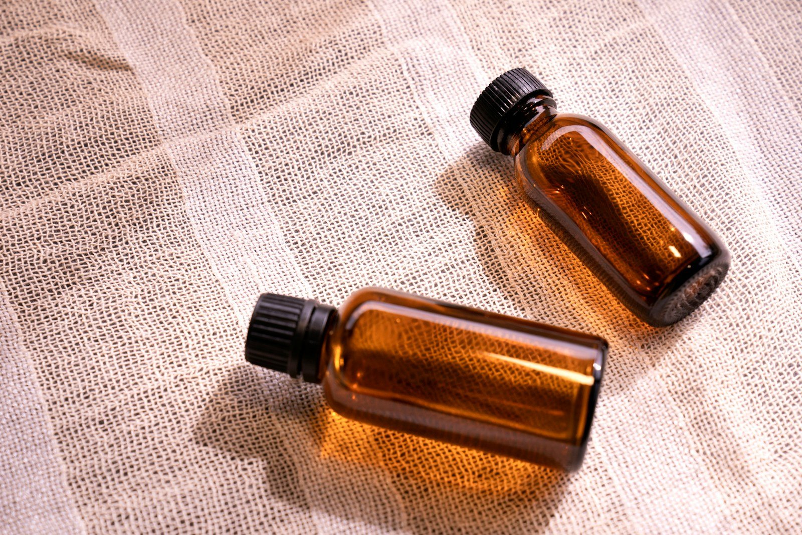 two small brown bottles sitting on top of a table, chemistry of poison